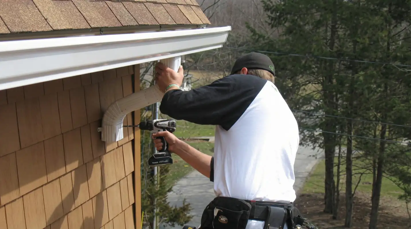 Professional contractor installing tan vinyl siding panels on a residential home exterior in Naperville, IL